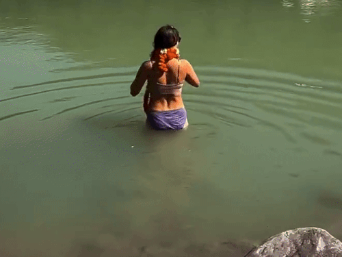 बिकिनी पहन गंगा स्नान करने पर ट्रोल हुई विदेशी महिला:ऋषिकेश में पोज दिए, नदी में उतर माला फेंकी, यूजर्स बोले- नागा भी ऐसे ही नहाते हैं