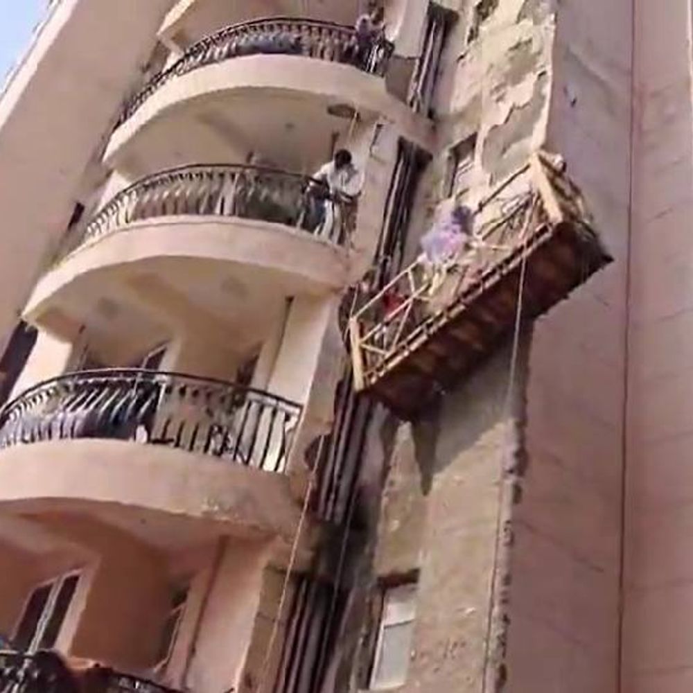 नोएडा की सोसाइटी में क्रेडल का तार टूटा:तीन तार के सहारे फंसा मजदूर, फ्लैट से रस्सी बांधकर बचाई गई जान