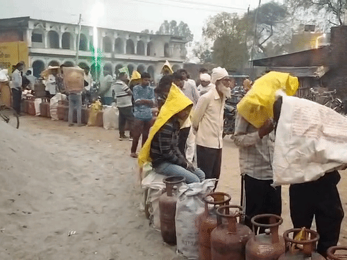 बारिश में सिर पर बोरी रखकर सिलेंडर लेने पहुंचे लोग:गोंडा में लोगों ने गैस एजेंसियों पर लाइन लगाकर करते रहे बारी का इंतजार