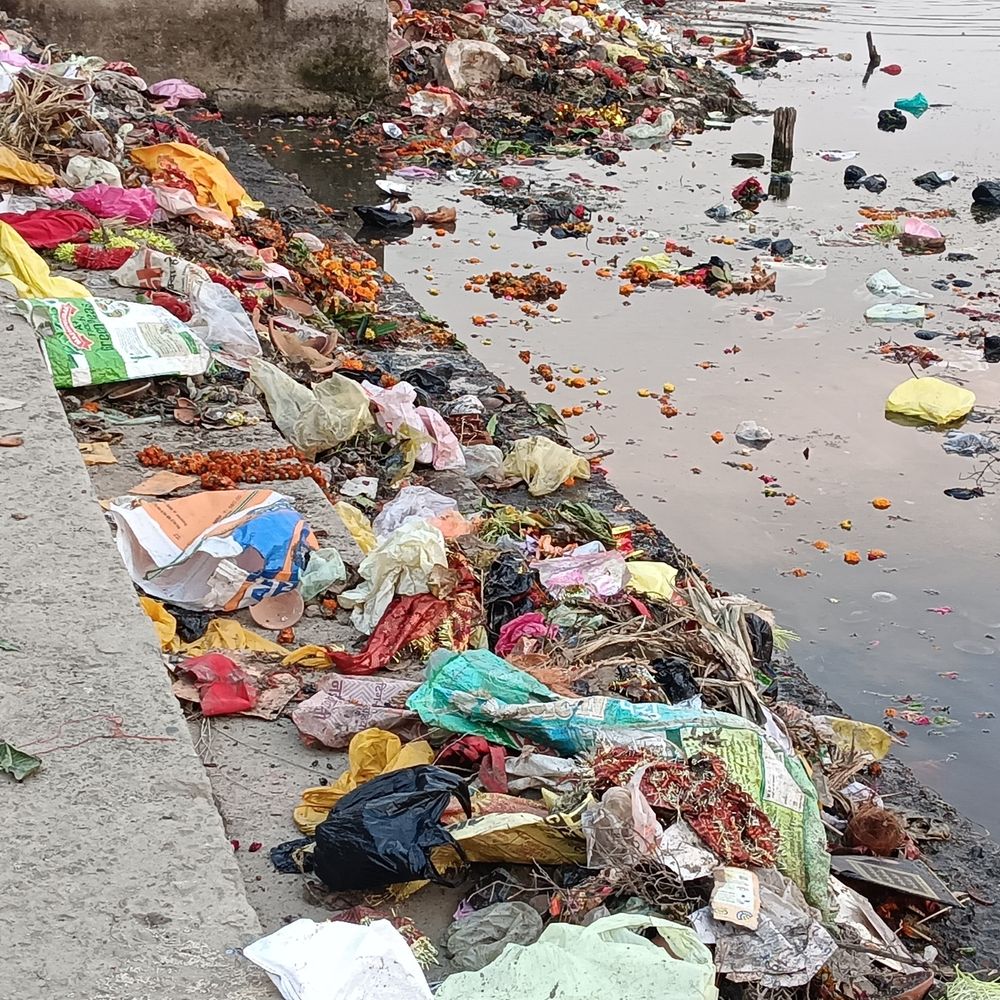 अमहट घाट पर कूड़े का अंबार:श्रद्धालु पूजा सामग्री सीधे नदी में डाल रहे, प्रशासन से सफाई की मांग