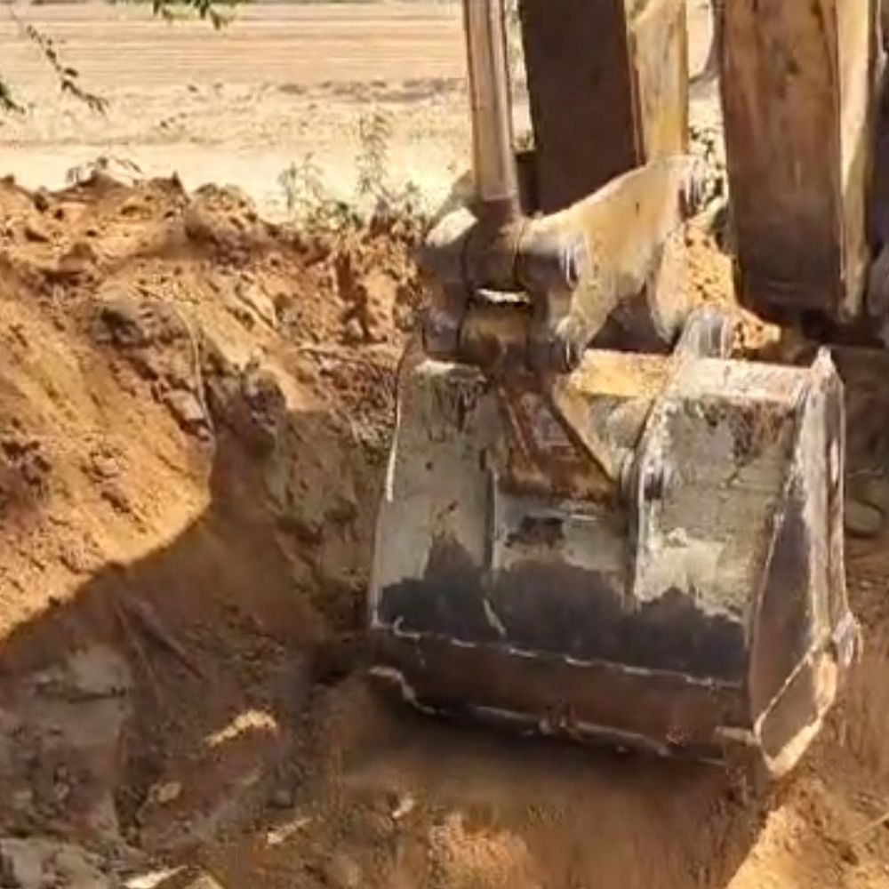 हाथरस में कब्रिस्तान पर चला बुलडोजर, शव बाहर आए:पानी की टंकी का हो रहा निर्माण, ग्रामीणों के विरोध के बाद काम रोका