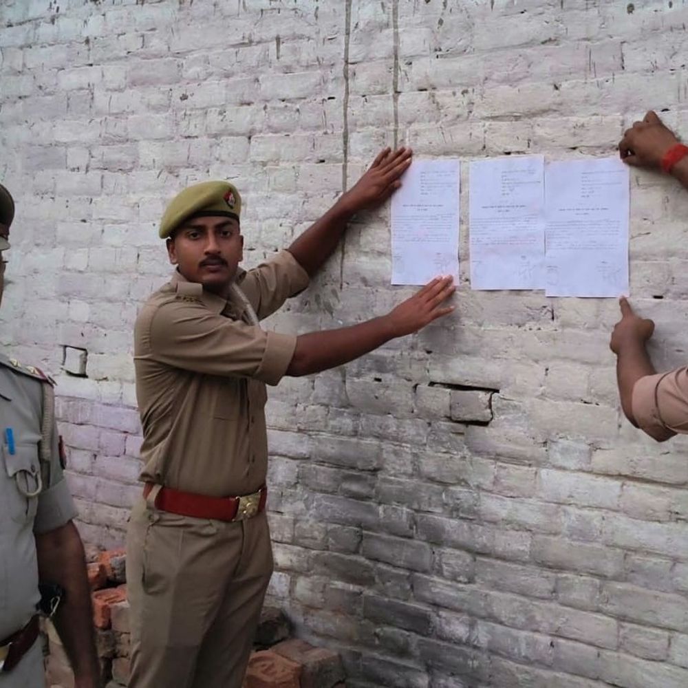 हत्या के फरार आरोपियों के घर पुलिस की मुनादी:देवरिया में न्यायालय के आदेश पर नोटिस चस्पा