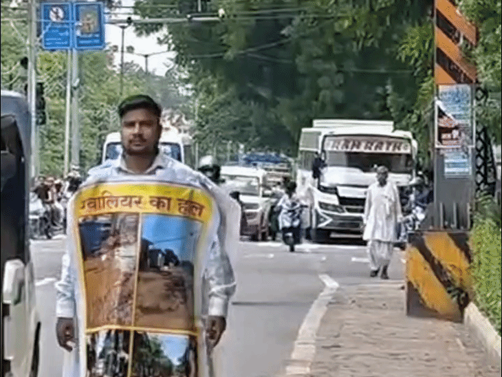 ग्वालियर में गड्ढों वाली सड़कों पर अनोखा प्रदर्शन:युवक शरीर पर पोस्टर लपेटकर सांसद से मिलने निकला