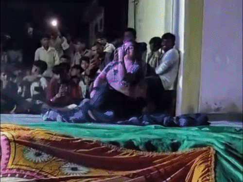 स्कूल परिसर में नाचती नृत्यांगना:बुरहारपुर में पंचायत-सदस्य प्रतिनिधि ने बरसाए नोट; देखने आसपास बैठे बच्चे