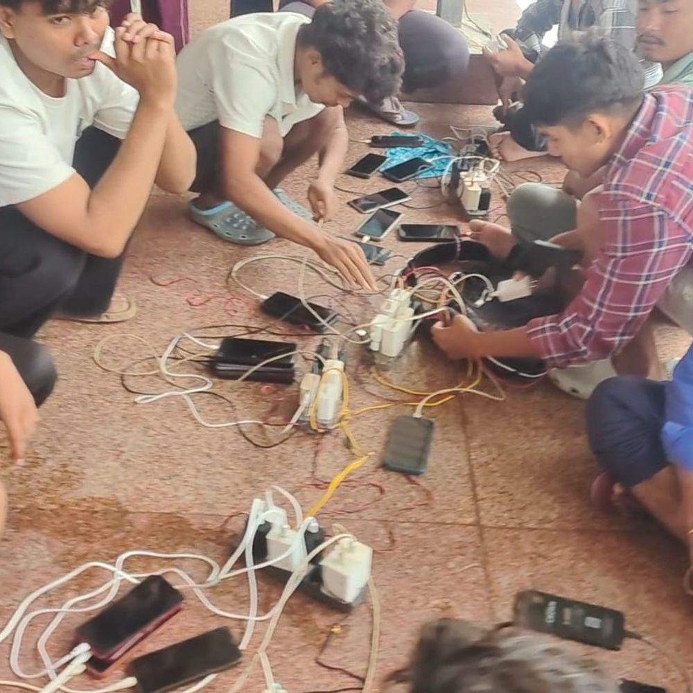लखीमपुर में बिजली गुल, रेलवे स्टेशन बना चार्जिंग सेंटर:सॉकेट के लिए लगी लोगों की कतार, घरों के इन्वर्टर भी हुए बंद