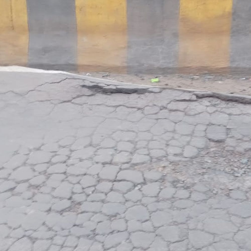 आमापारा पेट्रोल पंप के पास सड़क धंसी डिवाइडर पर जमा डामर की मोटी परत