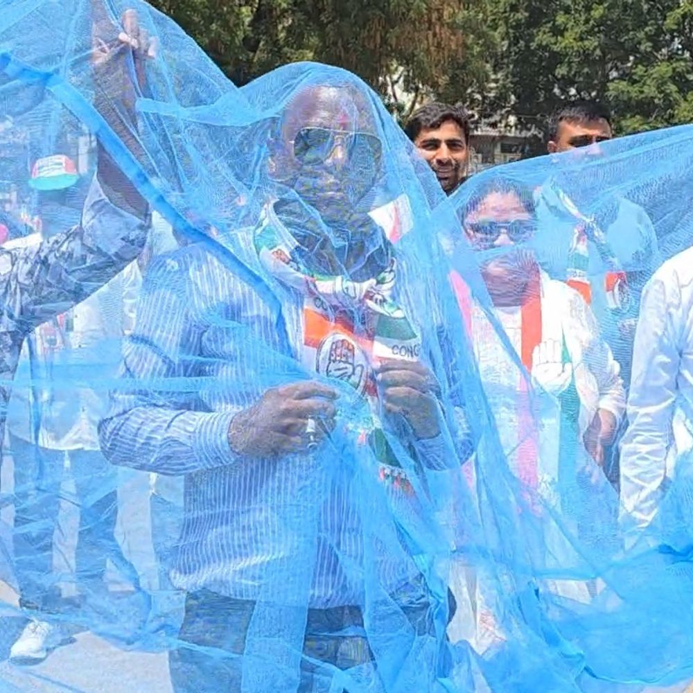 નવસારીમાં કોંગ્રેસ ઉમેદવારનો અનોખો વિરોધ:મચ્છરદાની પહેરી દૂષિત પાણીની બોટલ સાથે ફોર્મ ભર્યું