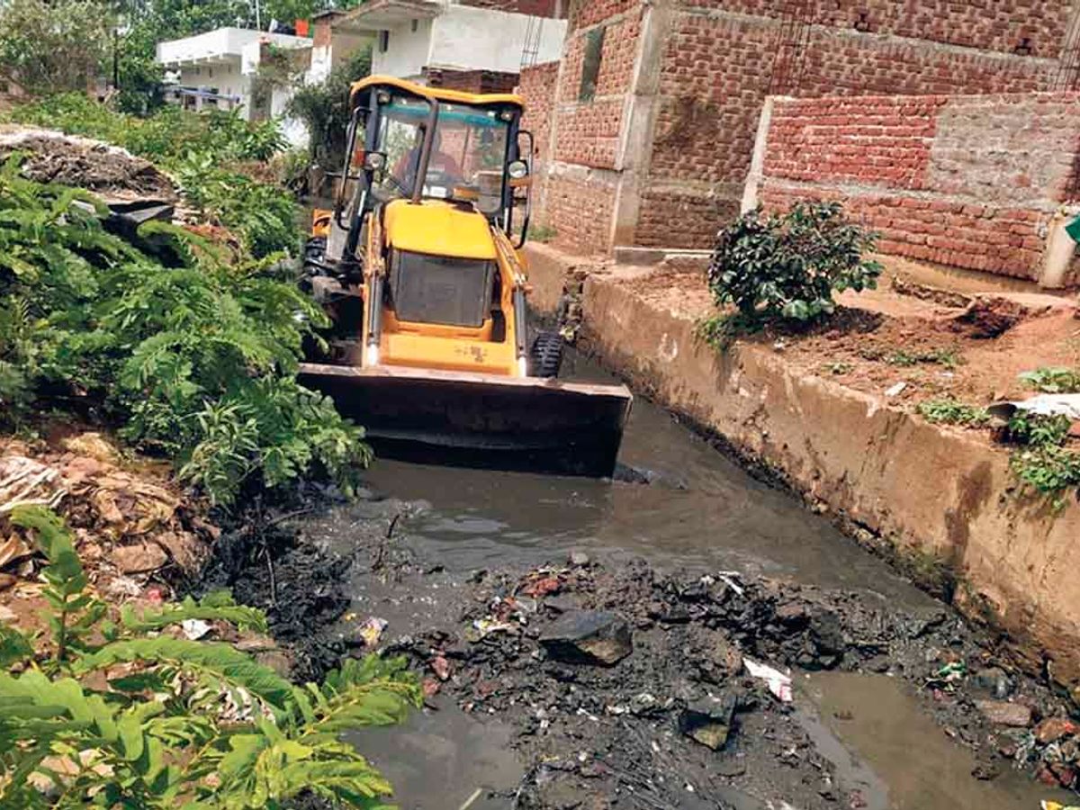 JCB machine lowered into the drain for cleaning