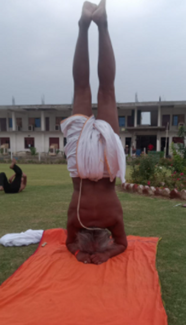 शीर्षासन सिखाते हुए महंत रामदास महाराज।
