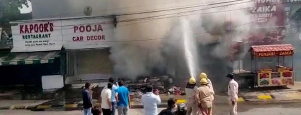 आग बुझाने की कोशिश करते दमकलकर्मी।