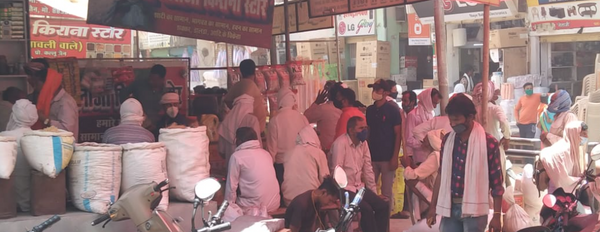 किराने की दुकान पर बैठे लोग अपनी बारी का इंतजार करते हुए।
