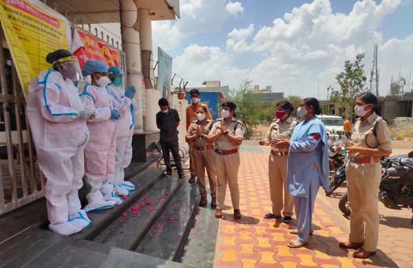 नर्सों को फूल देकर सम्मानित करती पुलिस की टीम