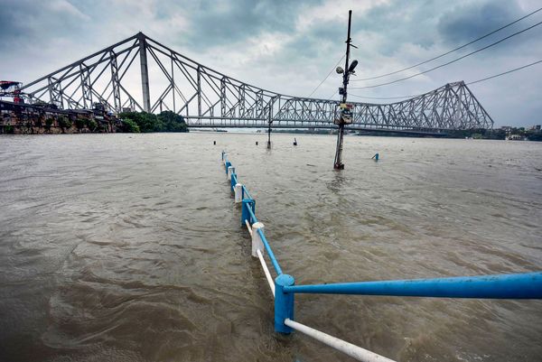 फोटो कोलकाता के हावड़ा ब्रिज की है। तूफान के साथ हुई बारिश के कारण नदी पर बने इस ब्रिज के पास रेलिंग तक पानी भर गया।