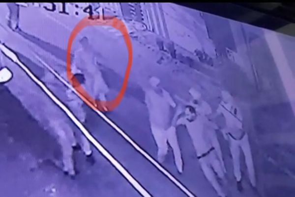 CCTV फुटेज में हमलावर को पकड़कर ले जाती पुलिस के पीछे आती महिला।