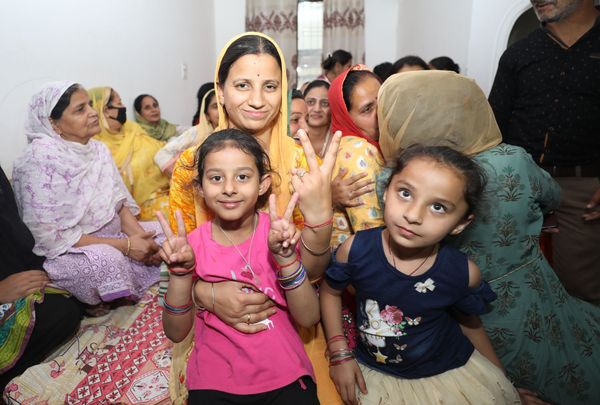 मीनू की गोद में बैठी उनकी बेटी को अब पापा के घर आने का इंतजार है। फोटो- अंकुर सेठी