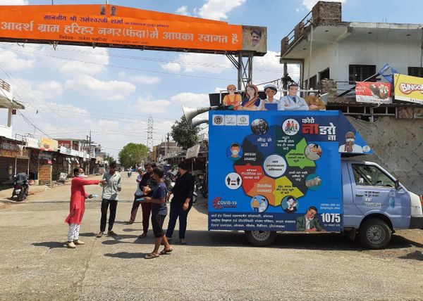 फंदा पंचायत के हरिद्वार गांव के मेन गेट पर ग्रामीणों को जागरुत करती युवाओं की टीम