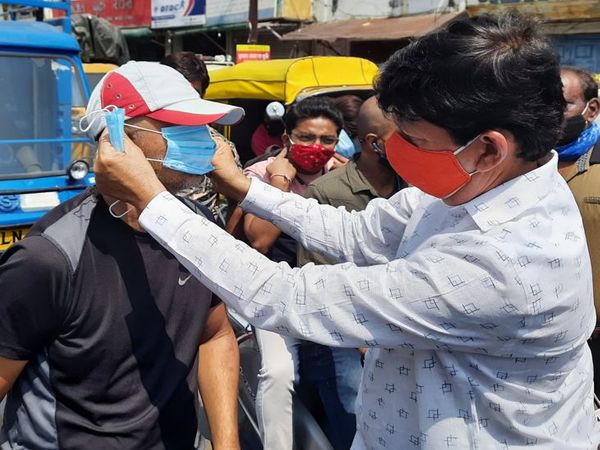 मेंदोला ने लोगों को मास्क पहनाए।