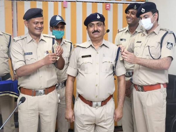 कंट्रोल रूम प्रभारी रविंद्र सिंह के कंधे पर तीसरा सितारा लगाते हुए एसपी सिद्धार्थ बहुगुणा और एएसपी शिवेश सिंह बघेल।