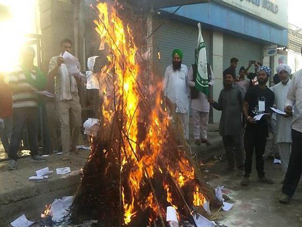 सोनीपत के कुंडली में हरियाणा-दिल्ली बॉर्डर पर होलिका दहन में कृषि कानूनों की प्रतियां जलाकर विरोध जताते किसान संगठनों के लोग।