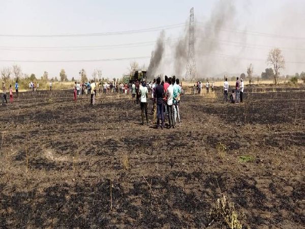 गेहूं की फसल जलने के बाद खेत में खड़े ग्रामीण।
