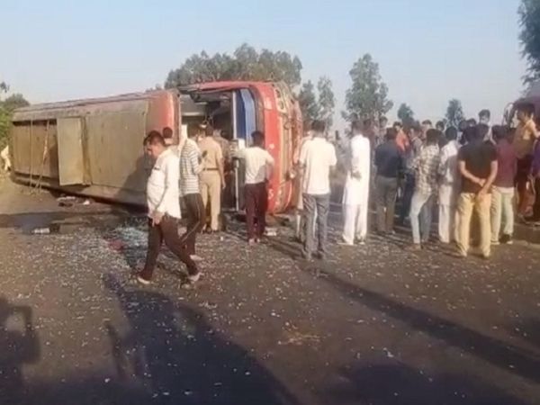 शादी में जा रहे स्कूटर पर सवार परिवार को बचाने की कोशिश के बावजूद उसे टक्कर मारने के बाद सड़क पर पलटी बस और मौके पर पहुंचे स्थानीय लोगों के अलावा पुलिस टीम।