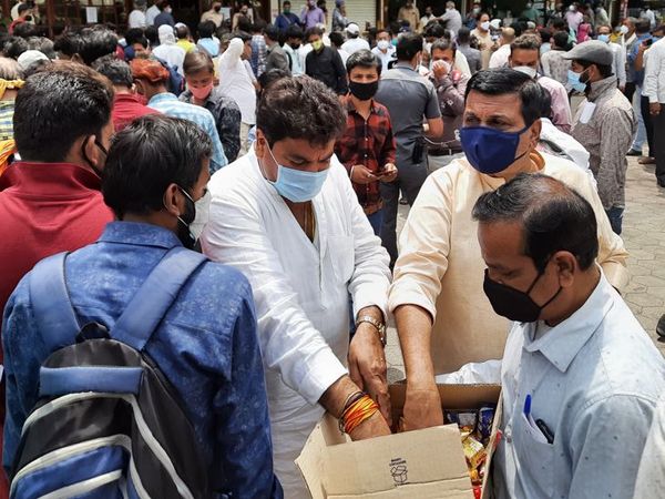 विधायक संजय शुक्ला ने धूप में खड़े लोगों को बिस्किट के पैकेट बांटे।