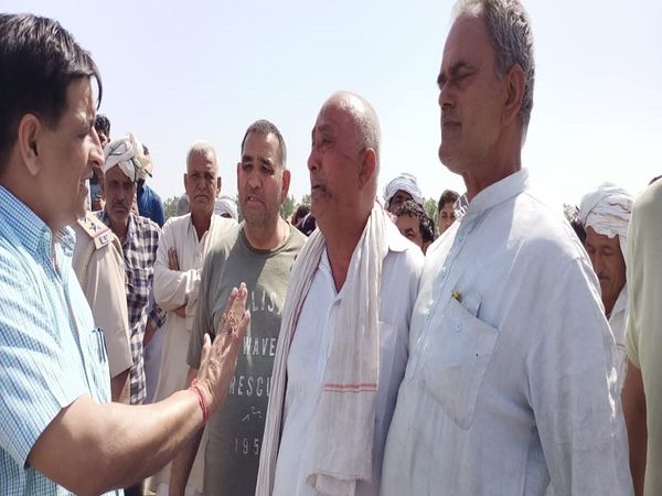 फसल को जलती देख भावुक किसान को मनाते BDPO जितेंद्र शर्मा।
