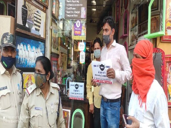 दुकानों में नो मास्क, नो सामान का पोस्टर लगवाती पुलिस।