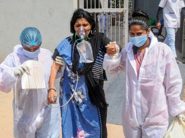 फोटो गुजरात के अहमदाबाद शहर की है। यहां कोविड अस्पताल में स्थिर हालत वाले मरीज को ICU से दूसरे वार्ड में शिफ्ट किया जा रहा है, ताकि गंभीर मरीज को ICU में बेड मिल सके। पूरे गुजरात के अस्पतालों में ICU, ऑक्सीजन और वेंटिलेटर का संकट है। - Dainik Bhaskar