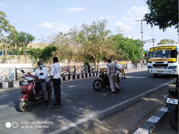सड़कों पर घूमते लोगों से पूछताछ करती पुलिस, जो सही वजह नहीं बता पाए उनके किए चालान।