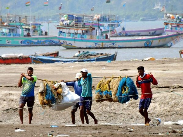 मुंबई में पूर्ण लॉकडाउन की संभावना के बाद अपने जाल को लपेटकर समद्र से बाहर आते मछुआरों की टोली।
