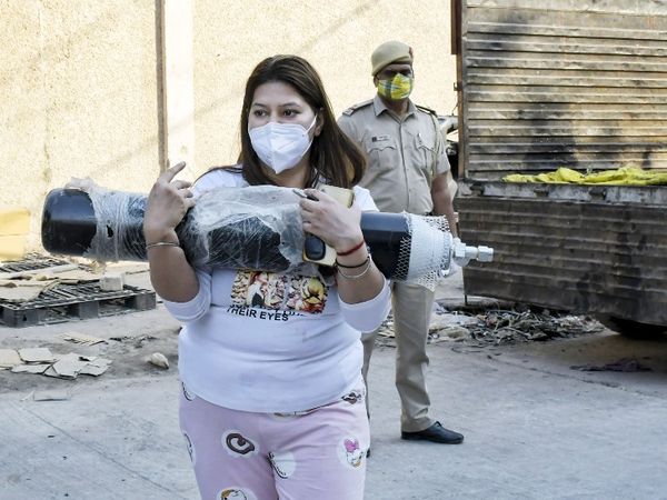 फोटो दिल्ली की है। यहां ऑक्सीजन सिलेंडर के लिए मयूरपुरी में कोविड-19 मरीजों के परिजनों की भीड़ जुट रही है। महिला सिलेंडर उठाकर ले जाते हुए।