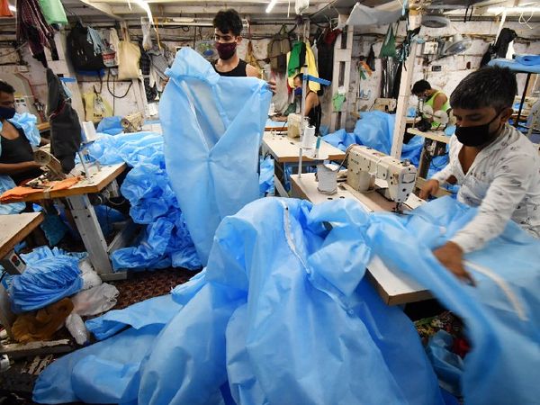 मुंबई के धारावी में PPE किट बनाते लोग। संक्रमण के बावजूद अतिआवश्यक सेवाओं से जुड़े उद्योग चल रहे हैं।