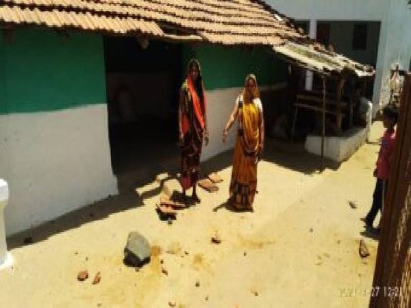 घर के पास गिरे पत्थरों को दिखाती महिलाएं।