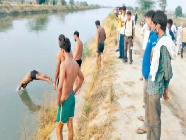 नहर में डूबे युवकों की तलाश करते गोताखोर।