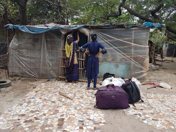 प्लास्टिक बांधकर अपनी झोपड़ी को सुरक्षित रखने की कोशिश करता एक परिवार।