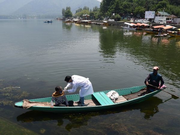 जम्मू-कश्मीर की राजधानी श्रीनगर में शनिवार को डल झील में नाव चलाने वालों के लिए खास वैक्सीनेशन ड्राइव चलाई गई। टीम ने शिकारा चलाने वालों को उनकी नाव में जाकर कोरोना का टीका लगाया। - Dainik Bhaskar