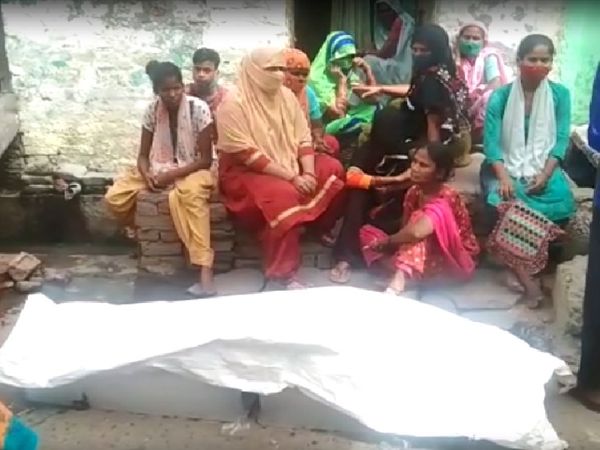जहरीली शराब पीने से जान गंवाने वाले के शव के पास रोते-बिलखते परिजन।