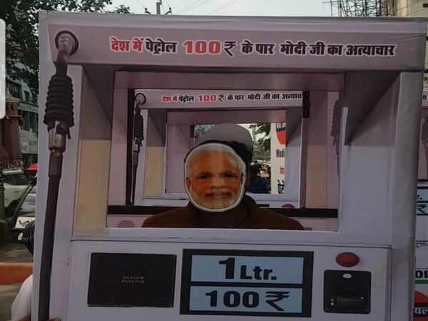 रायपुर की सड़क पर पंप उठाकर चलते मोदी जी बने युवकों को लोग देखते रहे।