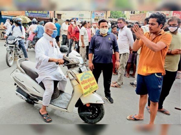 पुराने गाेहाना अड्डे पर जाम के दाैरान लाेगाें काे दूसरे रास्ते से जाने के लिए कहते परिजन।