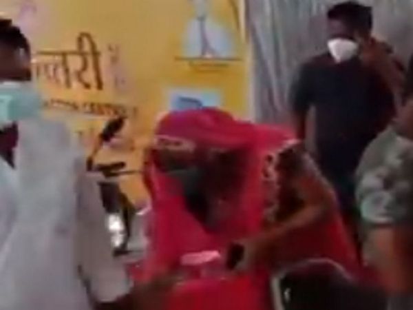 महिला ने मंत्री के पैर छूने की कोशिश की, मंत्री ने उन्हें आराम से वैक्सीन लगवाने को कहा।