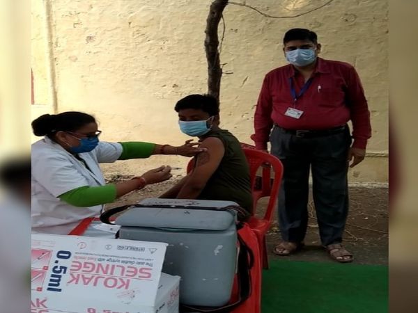 अस्थायी कैंप में वैक्सीन लगवाता युवक