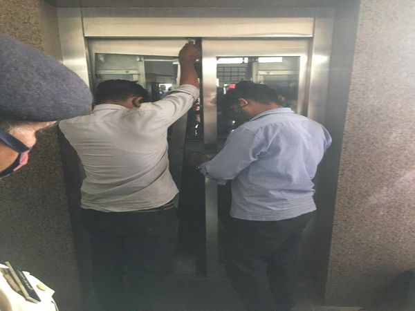 लिफ्ट को खोलने का प्रयास करते मैकेनिक।