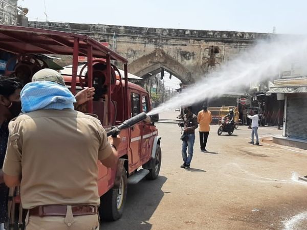 कोरोना संसर्ग रोखण्यासाठी रस्त्यांवर सॅनिटाइजेशनचे कामे करणारे पोलिस कर्मचारी.