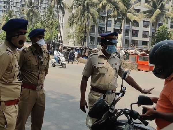 मुंबई के कुर्ला पूर्व क्षेत्र में लोगों की जाँच करते पुलिसकर्मी।