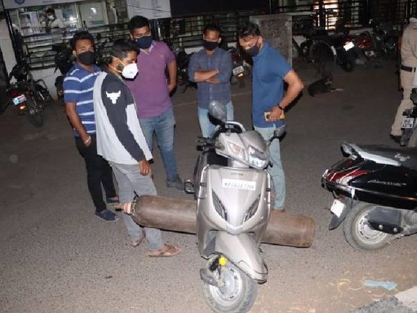 इंदौर में ऑक्सीजन सिलेंडर भरकर स्कूटी लाने की तैयारी कर रहे मरीजों के परिजन। यहां 3 हजार गंभीर रूप से बीमार मरीज भर्ती हैं।