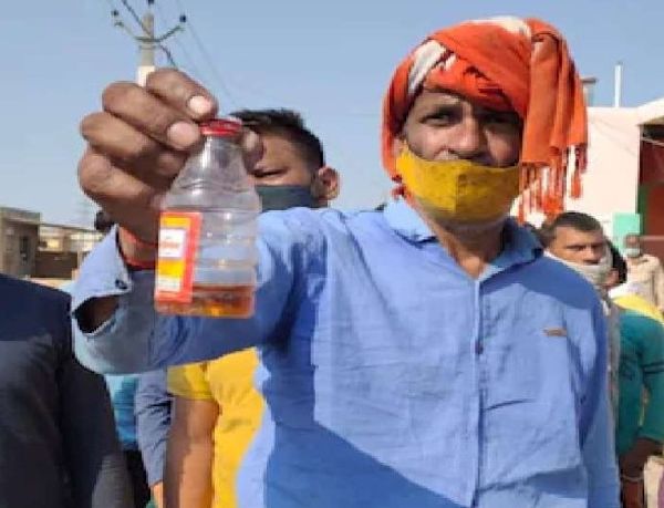 जहरीली शराब का बोतल दिखाते गांव के लोग।