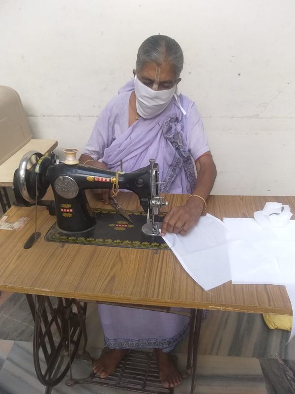 आत्मनिर्भर बन रहीं माता मास्क बनाते हुए
