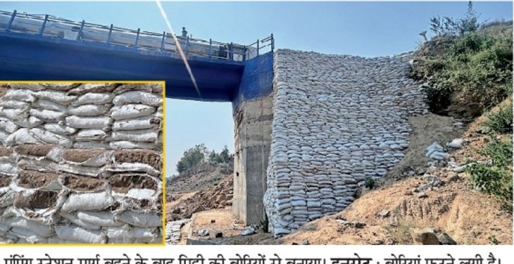 Pumping station road washed away in flood, built with sacks filled with ...