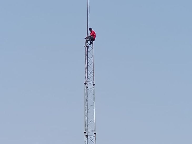 A young man climbed a 100 feet high mobile tower